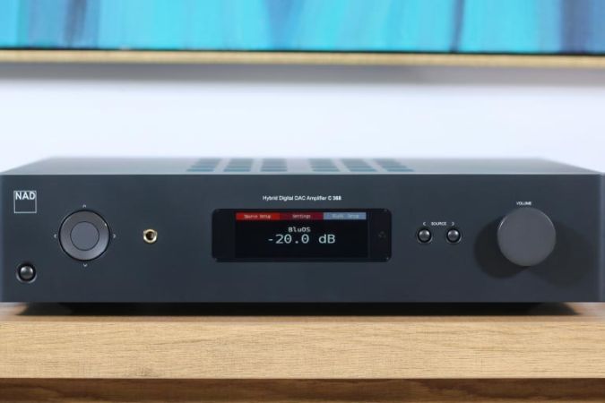A sleek black amplifier displayed on a wooden surface, showcasing a clear digital display and minimalistic controls.