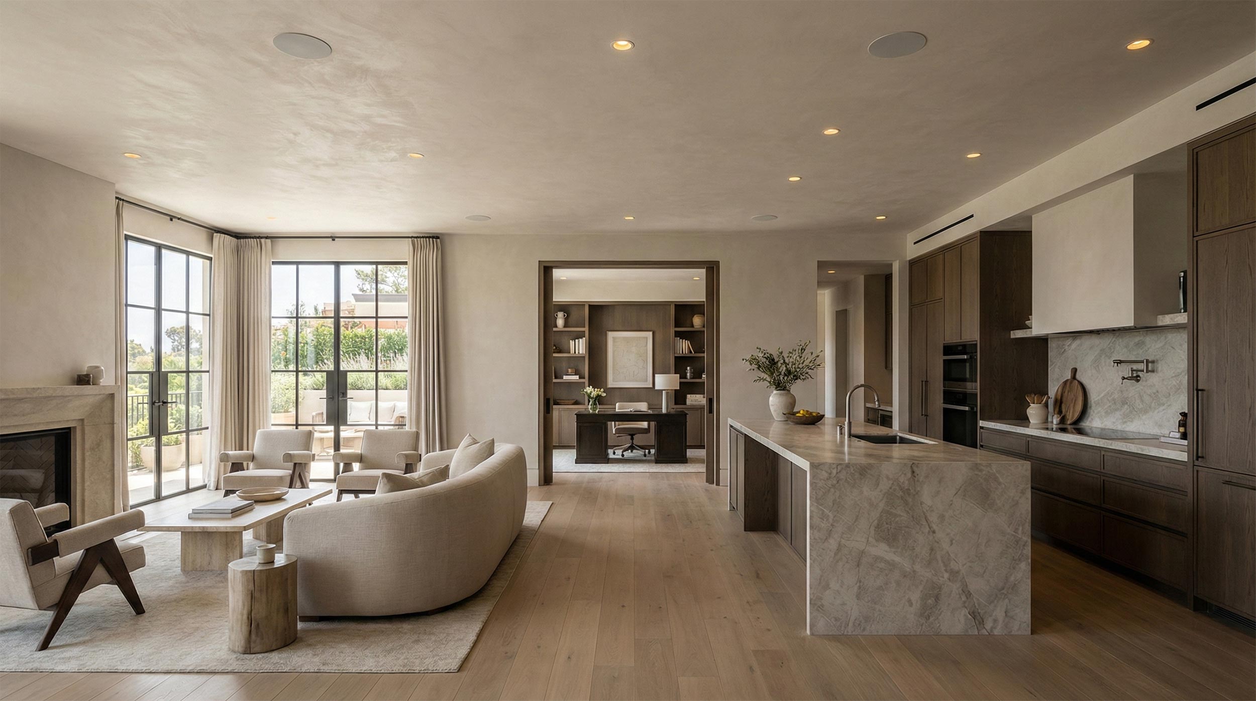 Open concept living and kitchen area with minimalist decor and recessed ceiling speakers