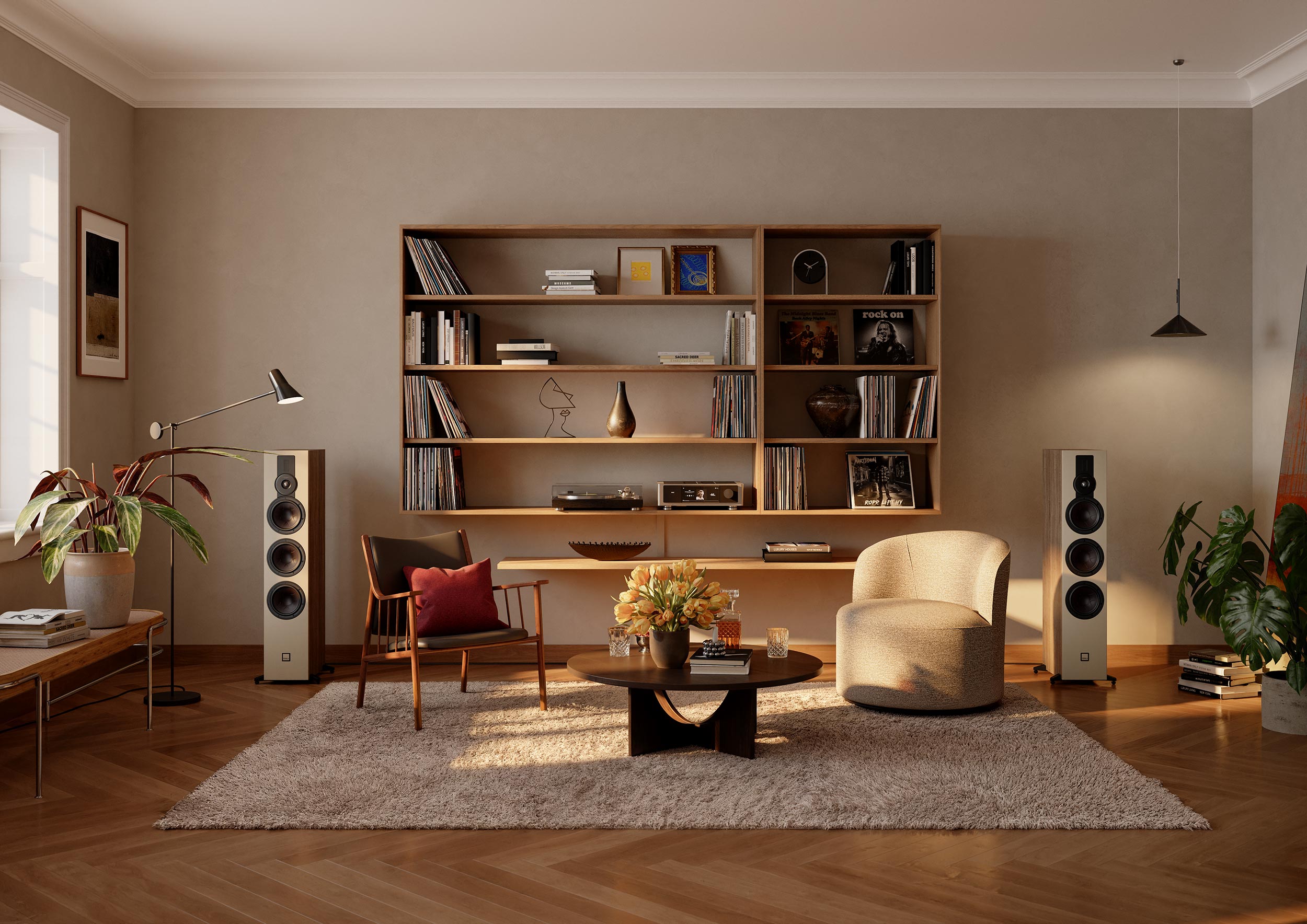 Living room setup with two tall wooden tower speakers and a large bookshelf