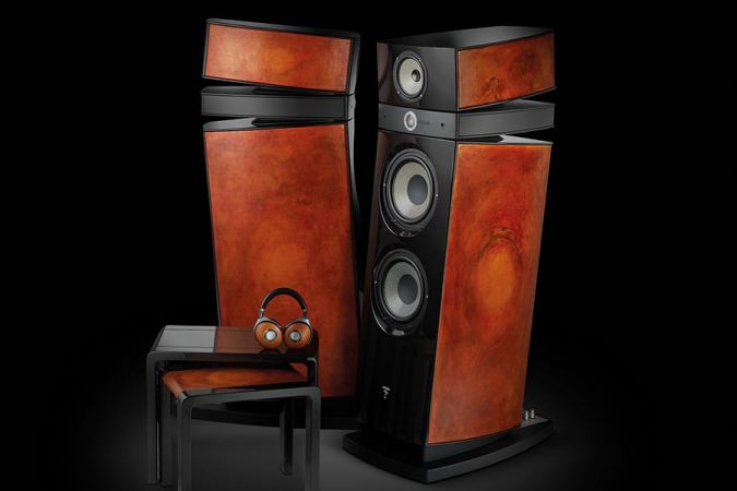 Two tall wood-paneled speakers and headphones resting on a small stool