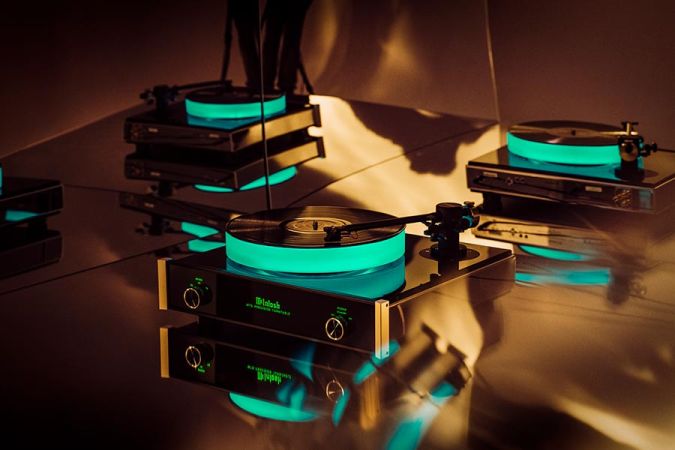 Record player with a glowing green illuminated platter on a dark table
