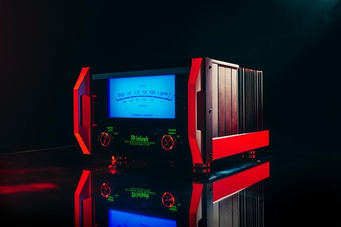 Audio amplifier with a blue meter and red handles on a reflective surface
