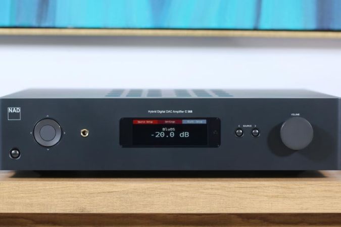 A sleek black amplifier displayed on a wooden surface, showcasing a clear digital display and minimalistic controls.